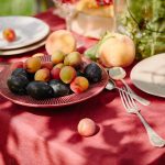 fruits, forks and plates on table in garden